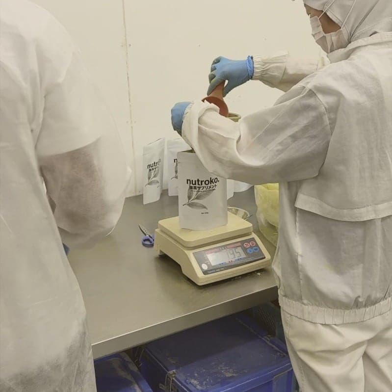 Filling a Nutroko pouch on the bench scale at the Osaki-cho factory, one scoop at a time