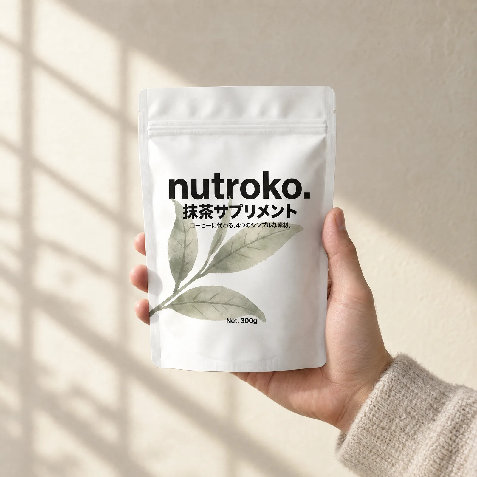 A hand holding the Nutroko pouch in shoji-filtered morning light