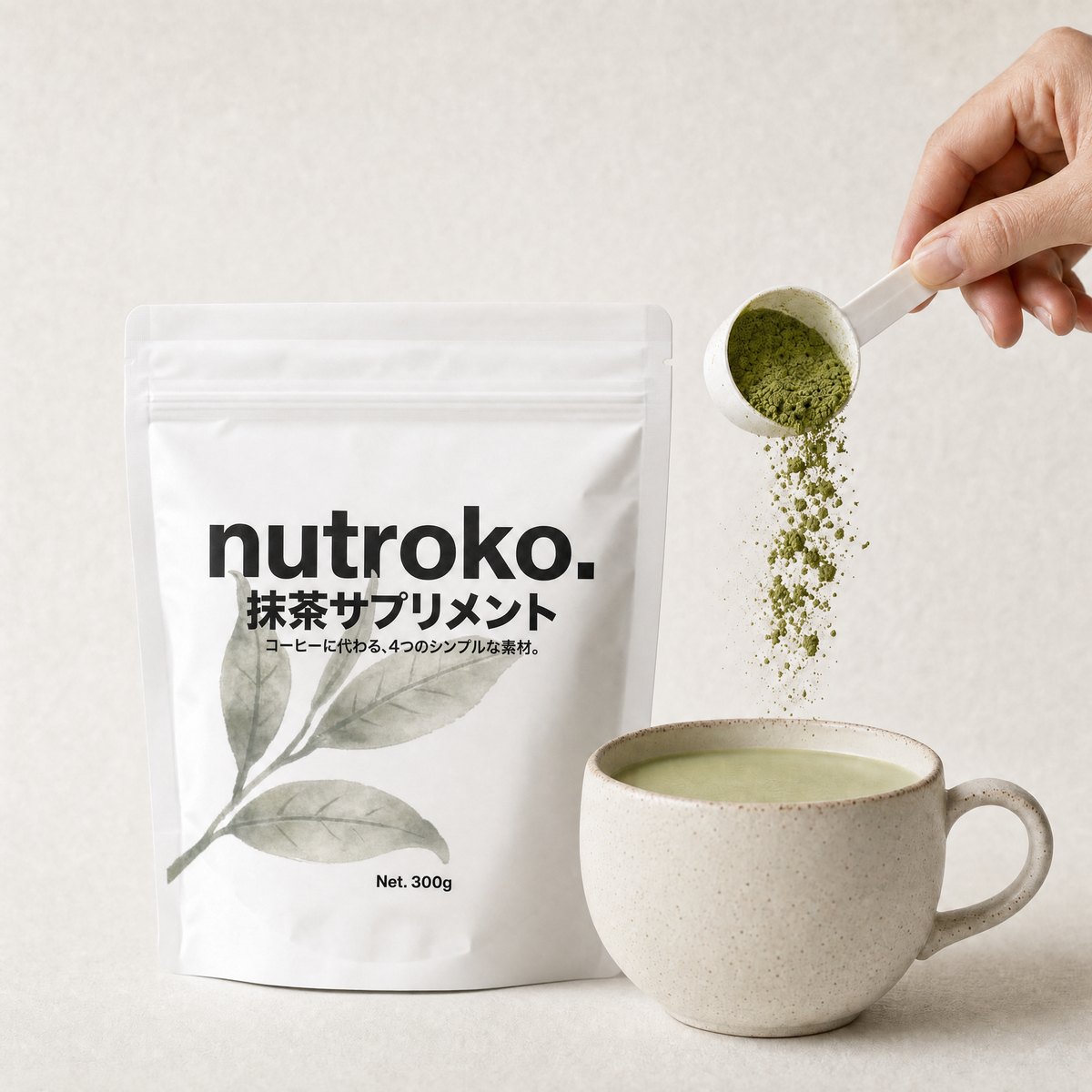 Nutroko pouch beside a stoneware mug of the prepared matcha supplement, a hand tipping a scoop of green powder above the mug